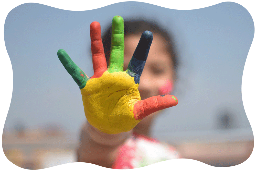 手のひらに絵の具をカラフルに塗った女の子の写真