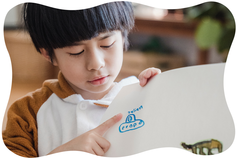 自分の描いた絵を説明する男の子の写真